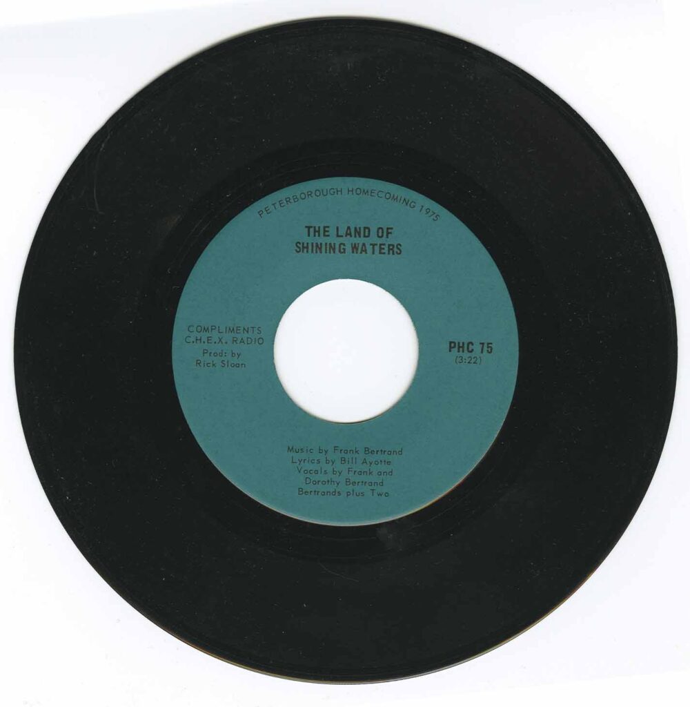 A black 45 record with green centre label. The label, "Land of Shining Waters by Frank Bertrand". 